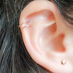 a close up of a person's ear with two piercings on the side