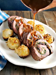 a white plate topped with meat covered in gravy