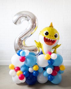 Lasts 3 to 5 days. See Longevity Notes. Some items are Inflated with helium. Some items are Inflated with air. This item is Ready-To-Party™ Handcrafted piece. May vary from picture. Features Make a bold birthday statement for a fun Baby Shark themed kids birthday! Use this giant balloon with tassel garland and number pedestal to dress up any space! This design includes a silver mylar number and Baby Shark mylar balloon for extra fun. This set is Ready-To-Party™. Comes inflated and assembled. Simply unbag and enjoy. Details NUMBER PEDESTAL Color Palette: Balloon - Dark Blue, White, Pale Blue, Hello Sunshine, Wildberry Foil - Silver number, Yellow Baby Shark foil Dimensions: H (per foil) - approx. 3ft W (per foil) - approx. 1.5ft W (total) - approx. 3ft Material: Balloon - biodegradable late Baby Shark Balloon Garland, Balloon Bouquet Baby Shark, Shark Birthday Balloons, Baby Shark Backdrop Balloons, Ballon Arch Baby Shark, Shark Balloon, Shark Themed Party, Balloon Tassel, Silver Numbers