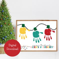 a christmas card with two hand prints on it next to a small tree and a basket