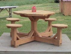 a wooden picnic table with stools on top