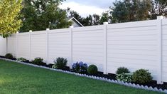 a white fence with flowers and bushes in the front yard