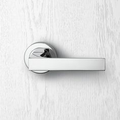 an image of a door handle on a white wood background that looks like it has been painted