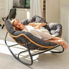 a woman laying in a rocking chair on the floor