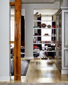 an open living room with wooden floors and bookshelves