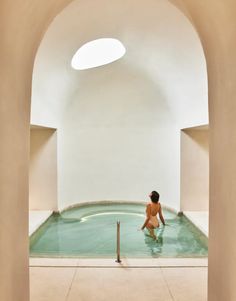 a woman sitting in the middle of an indoor swimming pool