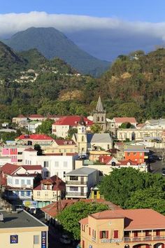 a city with mountains in the background and houses on the hillsides below, as seen from above