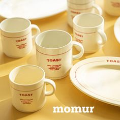 there are many cups and plates on the table with each one's own name