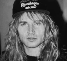 a man with long hair wearing a hat