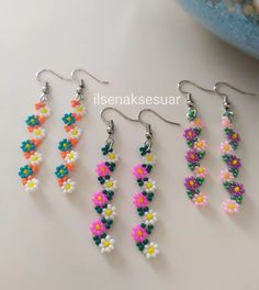 four pairs of colorful beaded earrings sitting next to each other