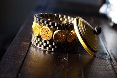 two bracelets sitting on top of a wooden table next to each other with yellow buttons