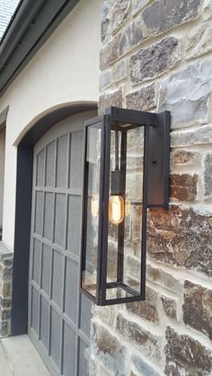 a light that is attached to the side of a building next to a garage door