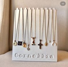 the necklaces are on display in front of a white sign that says, comelia