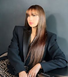 a woman with long hair sitting on top of a table