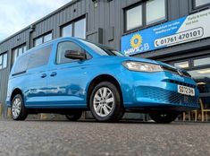 a blue van parked in front of a building