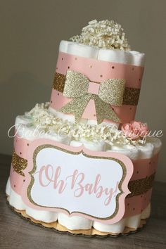 a pink and gold diaper cake on a table