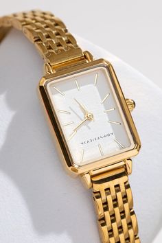 Introducing the Mila 18K Minimalist Watch, a luxurious timepiece crafted for the modern Woman. Featuring a lustrous 18K Gold detail, It's sleek design perfectly combines functionality and style. The band is expertly crafted from premium quality stainless steel to ensure durability. Elevate your everyday look with the timeless elegance of Mila. Dial Size: 26*20mm Band Width: 14mm Band Length: 23cm Movement: Japanese Quartz Each Watch will be delivered in our luxe black and gold watch box Please n Elegant Woman Watch, Classic Gold Watch Women, Elegant Gold Watch, Gold Rectangle Watch, Timeless Watches Women, Women’s Gold Watch, Classy Gold Jewelry, Designer Watches Women, Women Gold Watch