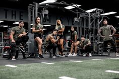 a group of people sitting on top of a bench in front of a crossfit gym