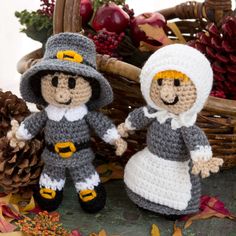 two crocheted amigurt dolls dressed as pilgrim and scarecrows holding hands