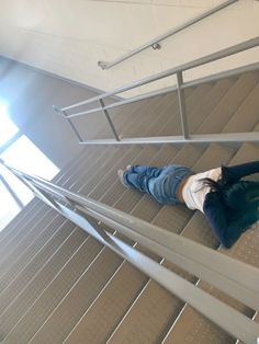 a person laying down on some stairs with their feet in the air and looking up