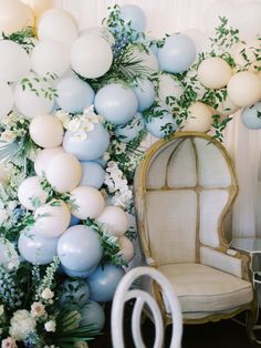 a room with balloons, chairs and flowers on the wall in it's centerpieces