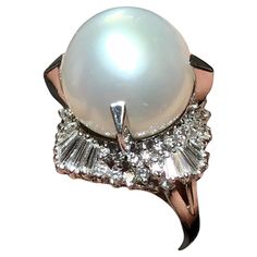 A large and impressive cocktail ring centered by a prong set 14.75mm white South Sea pearl with a very slight silver undertone exhibiting an even luster with extremely minor surface pitting. Surrounding the pearl is approximately 2.20cttw in H-I color Vs2-Si1 clarity round and baguette diamonds. Dimensions/Weight: Ring measures 1” in diameter and weighs 15.6g. Size 6 (sizable). Condition: All stones are secure and in perfectly wearable condition. R-OPPJ Pearl Cocktail Ring, Timeless Ring, Vintage Cocktail Ring, Golden South Sea Pearls, Diamond Cocktail Rings, Ring Crafts, Sea Pearls, South Sea Pearls, Pearl Diamond