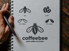 a person holding a pen and writing on a notebook with coffee logos in front of them