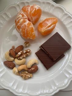 an assortment of nuts, chocolate and oranges on a plate