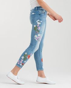 a woman in white shirt and jeans with flowers on the side