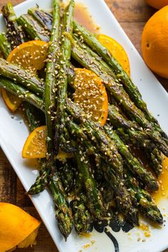 asparagus and oranges with sesame seeds on a plate