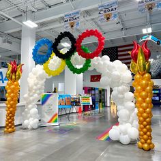 an indoor event with balloons and decorations in the shape of olympic rings