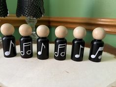 five black and white wooden pegs with musical notes on them sitting on a table