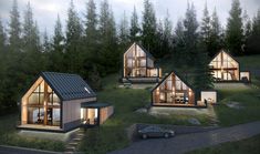 three small houses are lit up at night in the woods with trees and grass around them