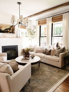 a living room filled with furniture and a fire place in front of a window on top of a rug