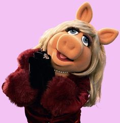 miss piggy talking on a cell phone wearing a fur coat and holding a purse