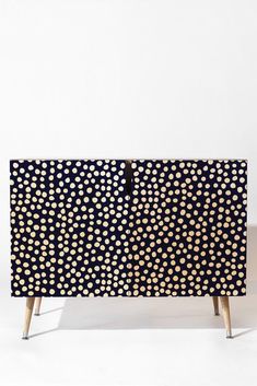 a black and white cabinet with gold dots on it