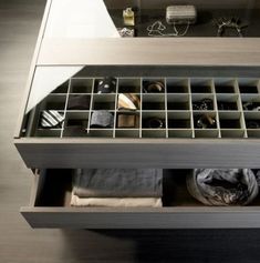 an open drawer with several pairs of shoes and accessories in it on a table top