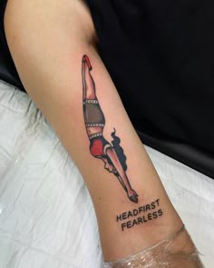 a woman's leg with a tattoo on it that says, head first fearless