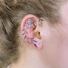 a person with a flower tattoo on their ear