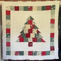 a quilted christmas tree hanging on the wall