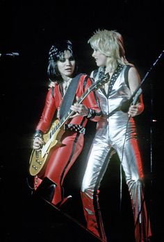 two people on stage with guitars and microphones