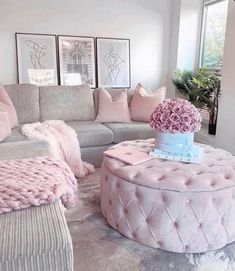 a living room filled with furniture and pink flowers on top of a round coffee table