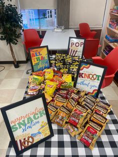 a table topped with lots of candy and framed pictures