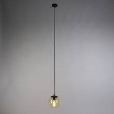 a light bulb hanging from the ceiling in a room with gray walls and flooring