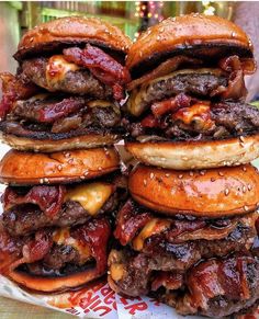 hamburgers stacked on top of each other with meat and cheese in the buns