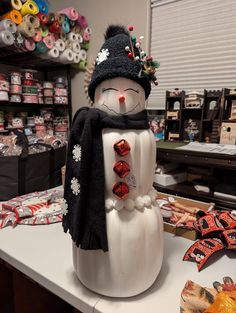 a snowman made out of plastic sitting on top of a counter next to candy