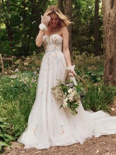 a woman in a wedding dress is posing for the camera with her hand on her face