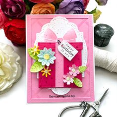 a close up of a card with scissors and flowers