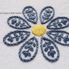 an embroidered flower on white fabric