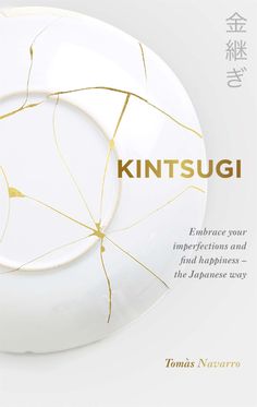 a white plate with gold lines on it and the words kintsugi written in japanese